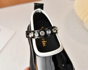 Detalle de merceditas de charol negro para niñas con correa de diamantes de imitación brillantes