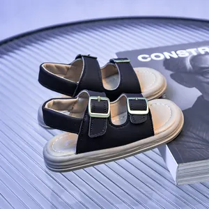 Detail of children's bicolor sandals with golden metal buckles and thick white soles