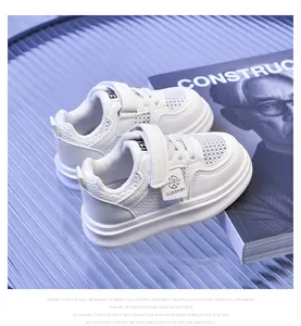 Detail of white mesh breathable kids sneakers with hook and loop closure on blue surface