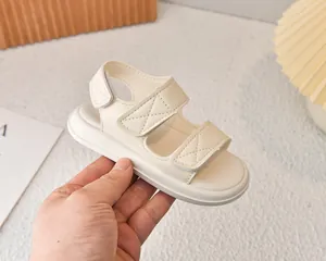 Dettaglio di sandali beige per bambini con doppia chiusura in velcro e morbida ecopelle