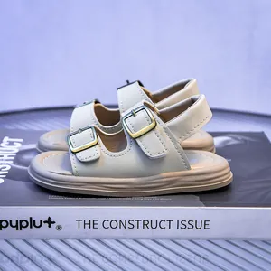 Detail view of beige toddler sandals featuring dual vintage metal buckles and soft soles