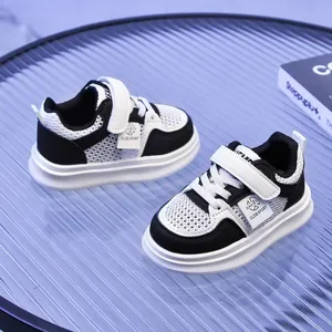 Detail of kids breathable mesh sneaker with velcro strap and black and white leather patches