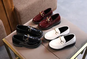 Close-up of shiny loafers in black, white, and burgundy with golden horsebit metal hardware