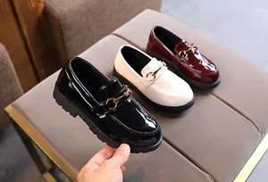 Detailed shot of kids patent leather loafers in black white and burgundy with horsebits