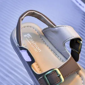 Detail of toddler sandals featuring brown faux leather, metal buckle, and contrast stitching