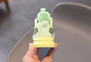 Vue arrière de basket enfant verte avec semelle jaune épaisse et languette de talon
