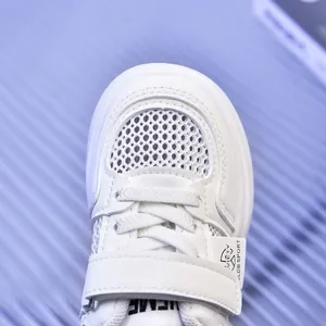 Macro detail of breathable mesh fabric and adjustable velcro strap on white kids sneakers