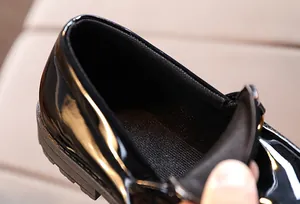 Macro shot of children's black patent leather shoe interior with breathable mesh lining