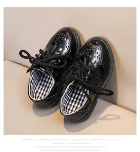 Vue détaillée de chaussures brogues noires vernies pour enfants avec motifs perforés