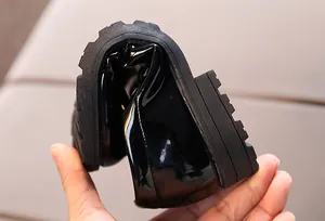 Close-up of flexible soft sole and black patent leather upper on kids loafers