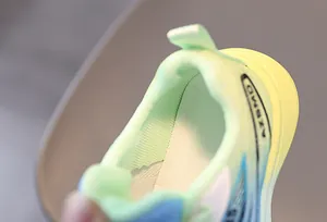 Détail du col rembourré et du mesh respirant sur les baskets enfant vert et bleu