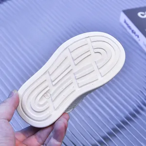 Close-up of the anti-slip sole on white children sneakers showing size 23 detail