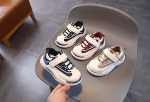 Dettaglio di quattro paia di sneakers casual per bambini in vari colori su una sedia