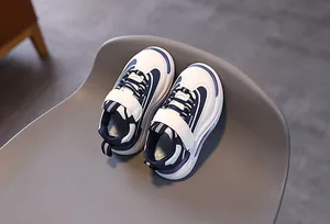 Dettaglio di sneaker casual per bambini con tomaia in pelle bianca e blu e velcro