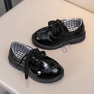 Détail de chaussures en cuir verni noir pour enfants avec semelles antidérapantes