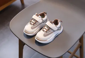 Dettaglio di scarpe sportive per bambini con velcro e scritte fashion su una sedia