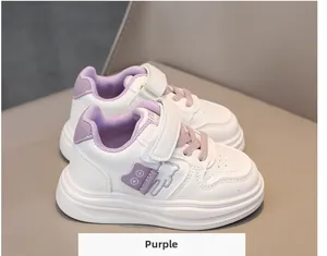 Detail of white kids sneaker with purple accents, teddy bear embroidery, and velcro strap