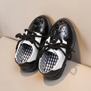 Gros plan détaillé de chaussures brogues noires et blanches pour enfants avec motifs