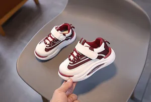 Dettaglio di scarpe da ginnastica per bambini bordeaux e bianche con velcro e suola
