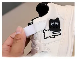 Detail showing kids' white leather sneakers with easy-to-use velcro strap closure