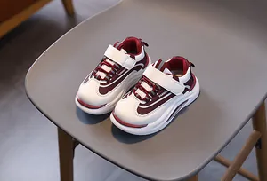 Dettaglio di scarpe sportive per bambini con chiusure velcro bordeaux e suola antiscivolo