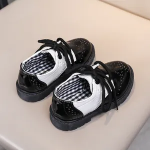 Détails de chaussures brogues noires et blanches pour enfants avec motifs perforés