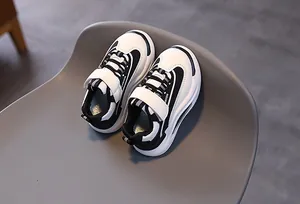Dettaglio di sneaker per bambini con chiusura a velcro su una sedia grigia