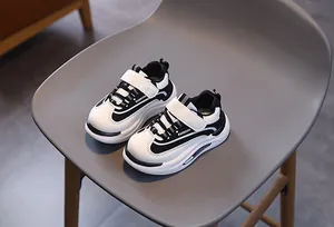 Dettaglio delle scarpe sportive per bambini bianche e nere con chiusura a strappo