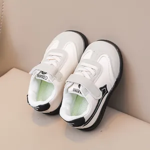 Dettaglio sneakers per bambini in pelle crema con inserti in camoscio e velcro