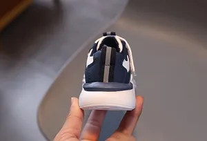 Dettaglio di scarpe casual per bambini con pelle blu navy e suola spessa bianca
