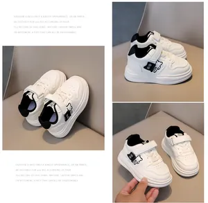 Detail view of white kids sneakers featuring a cartoon bear and velcro strap closure