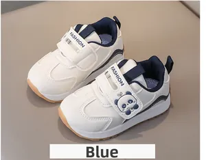 Detail of white kids sneakers with panda print, navy velcro strap and rubber sole