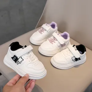 Detail of kids white sneakers with cartoon bear print and convenient velcro straps