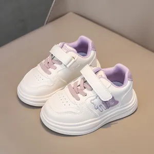Detail showing white and purple kids sneakers with velcro straps and soft rubber soles