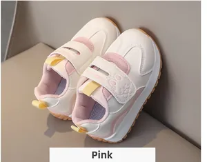 Detailed view of kids' pink sneakers with velcro strap and cute cartoon rabbit emblem