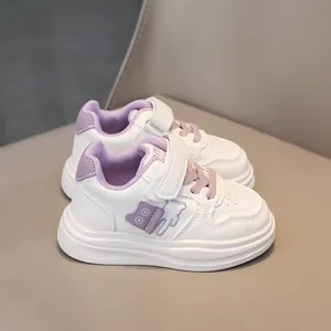 Detail view of white and purple kids sneakers with velcro straps and anti-slip thick soles