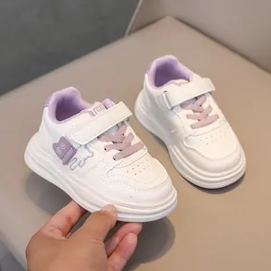 Detail view of kids white sneakers with purple velcro strap and bear decor