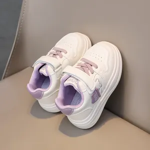 Detail view of children white leather sneakers with purple accents and bear relief