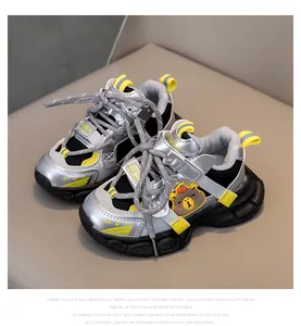 Detail of silver kids sneaker showing mesh texture and cute bear character ornament