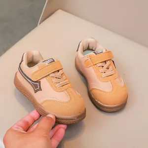 Dettaglio delle sneakers per bambini con velcro e patchwork in pelle beige e marrone