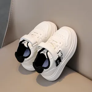 Detail of white children's sneaker with black bear pattern and soft leather texture