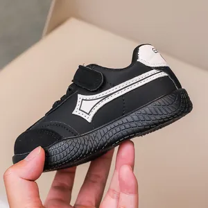 Dettaglio di scarpe nere per bambini con chiusura a strappo e suola in gomma antiscivolo