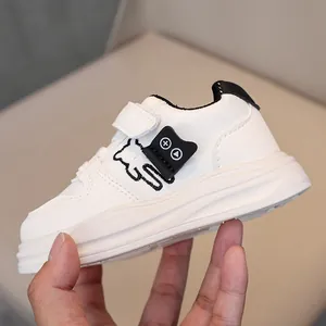 Detailed view of kids white sneakers with bear embroidery and soft leather texture