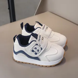 Detail view of children sports shoes featuring cute panda decoration and velcro straps