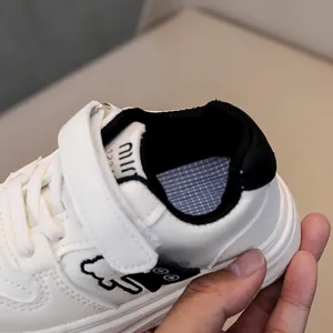 Detail of kids white sneaker with velcro strap and breathable mesh lining