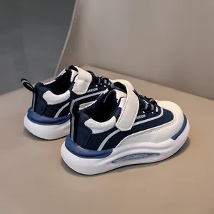 Dettaglio di scarpe sportive per bambini blu navy e bianche con chiusura a strappo