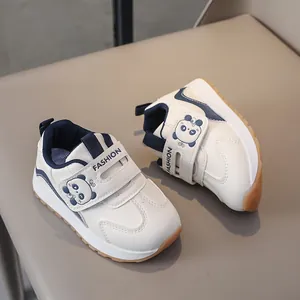Detail of kids sneaker with velcro closure and cute panda decoration on white leather