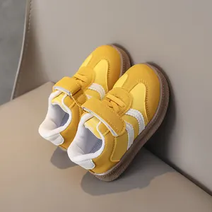 Detail of yellow kids sneakers with hook-and-loop closure and durable gum rubber sole