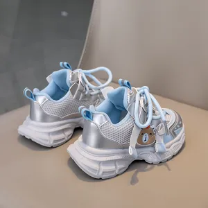 Detail of light blue kids sneakers with breathable mesh and cute bear patch decoration