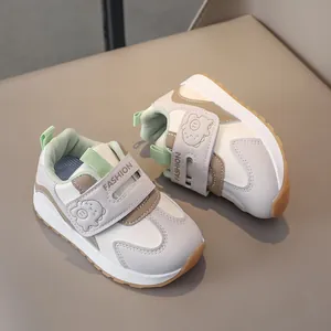 Detail of kids white sneakers with cartoon dinosaur velcro strap and rubber outsole